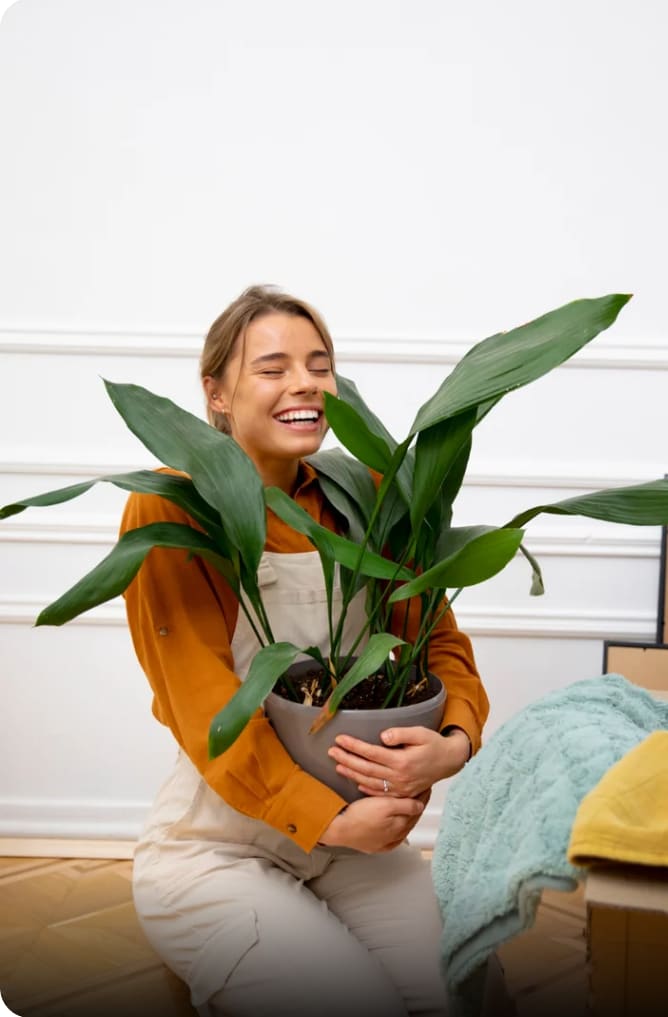 Clienta sonriendo mientras abraza una planta de interior recién elegida